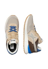Scarpe da ginnastica beige e marroni con accenti grigi e blu. Materiali in suede e rete, suola testurizzata e lacci blu. Branding evidente sulla linguetta.