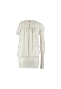 Blouse blanche à manches courtes avec encolure froncée, motif floral subtil sur les manches, fermeture éclair visible et étiquette de marque sur le devant.
