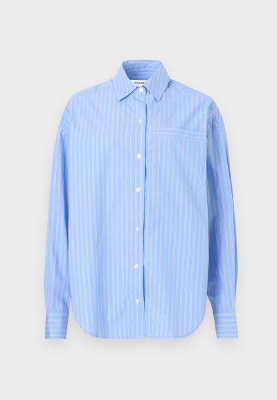 Ανοιχτό μπλε μακρυμάνικο πουκάμισο με άσπρες κάθετες ρίγες, γιακά με αιχμηρή άκρη και τσέπη στο στήθος, σε απλό φόντο.
