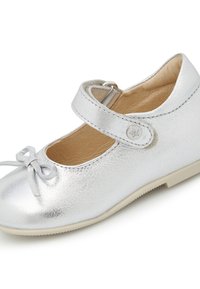 Zapato Mary Jane de cuero plateado con punta redondeada, detalle de lazo pequeño y correa ajustable. Presenta una suela de color claro y superficie texturizada.