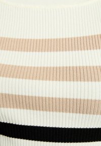 Haut en tricot côtelé avec des rayures verticales en crème, beige et noir. La texture est élastique, avec une coupe ajustée et une finition douce.