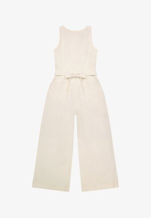 Bež predimenzioniran kombinezon brez rokavov z okroglo izrezom in širokimi hlačnicami, z modnim pasom, ki je zavezano zadaj na pasu.