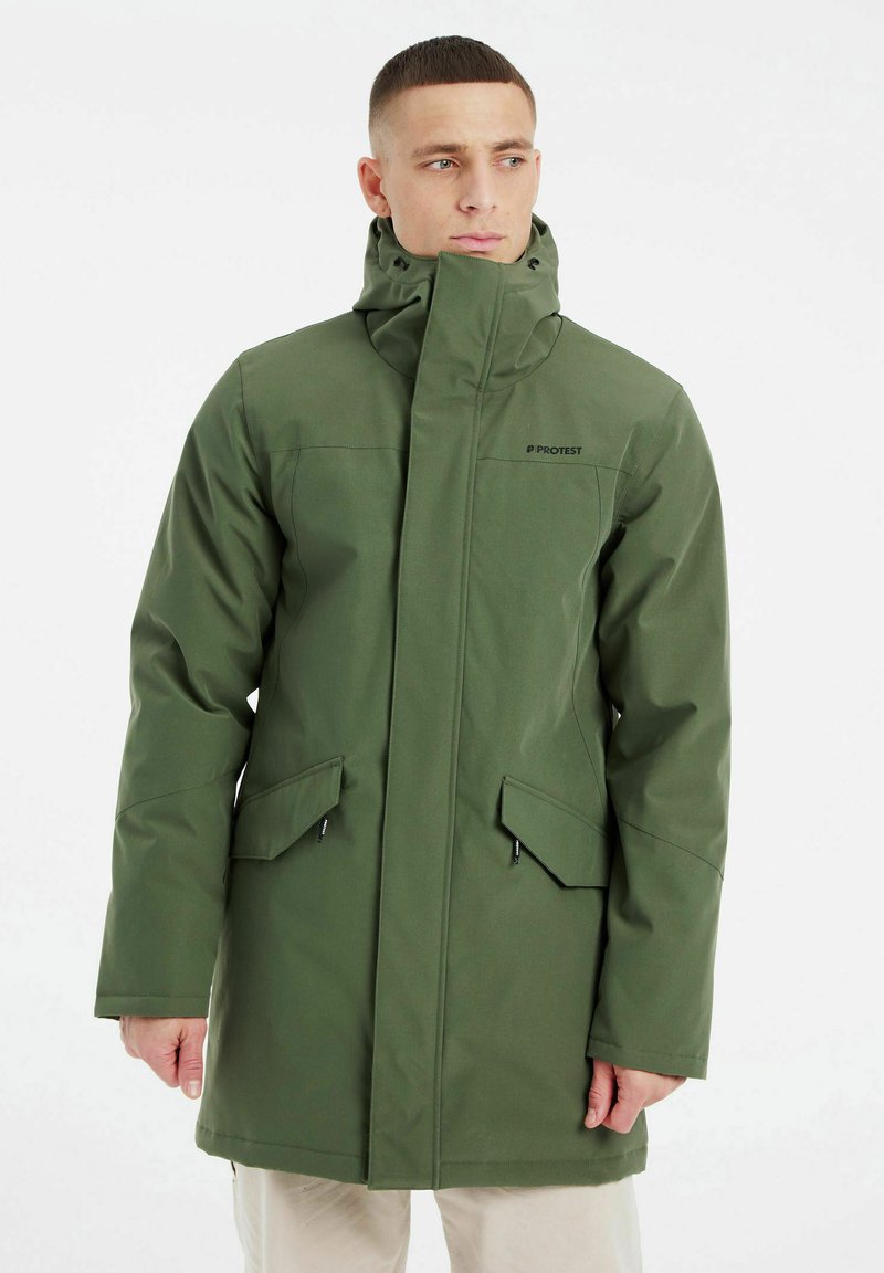 Manteau imperméable vert avec un col haut, fermeture éclair à l'avant et deux poches inclinées. Fabriqué en tissu lisse avec un design minimaliste.