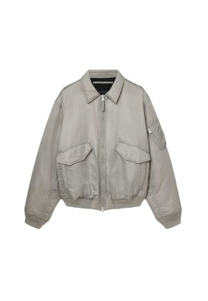 Světle šedá bomber bunda se zipem vpředu, která má dvě velké přední kapsy, malou kapsu na rukávu a žebrovaný spodní lem a manžety.