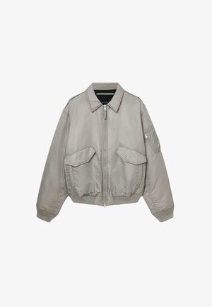 Gaišpelēka bumbers jaka ar priekšējo rāvējslēdzēju, divām lielām priekšējām kabatām, mazu kabatu uz piedurknes, kā arī ribota apakšmala un piedurknes.