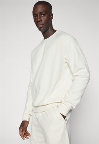 Nike Performance PRIMARY CREW - Mikina - pale ivory