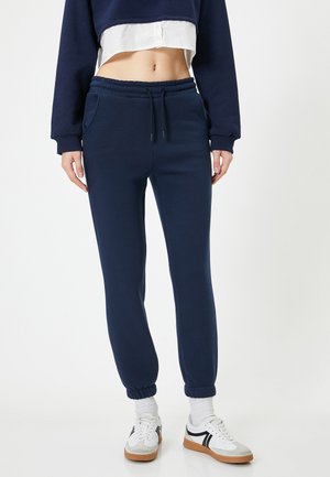 Marineblauwe joggingsbroeken van zacht stof, met een elastische tailleband, zijvakjes en geribbelde boorden bij de enkels.