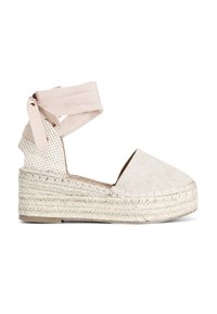 Espadrilles in tela beige con una piattaforma in juta intrecciata, dotate di un laccio alla caviglia in tessuto a nastro coordinato e una punta arrotondata e liscia.