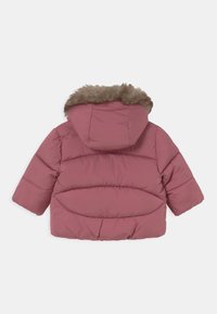 Lyserød polstret jakke med hætte i falsk pels, prydet med syede paneler og en rund kant. Stoffet ser glat og blødt ud.