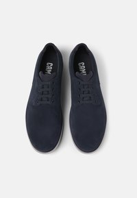 Marineblauwe suède schoenen met een gladde textuur, ronde neus, zes vetergaatjes en een gevoerde binnenzool met de merknaam "CAM."