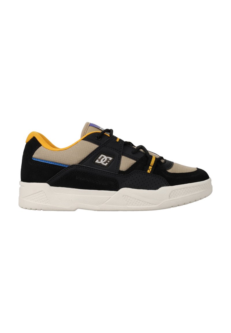 Svart och beige sneaker med mocka och mesh-material, gula detaljer, svarta snören, en vit mellansula och strukturerad gummiyttersula.