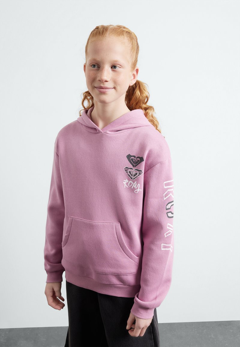 Haut à capuche rose avec une poche kangourou, avec un imprimé graphique sur la poitrine et la manche. Tissu doux et coupe décontractée.