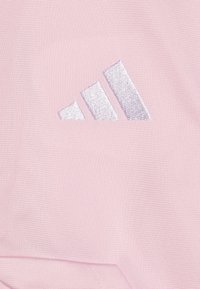 Lyserød atletisk stof med et sølvbesticket Adidas-logo bestående af tre parallelle striber. Teksturen er glat og let struktureret.