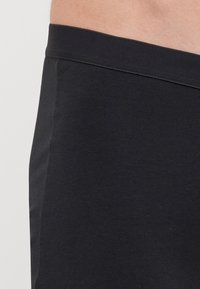Fekete pamut rövidnadrág sima textúrával, puha rugalmas derékkal a kényelem érdekében és egy egyszerű, letisztult kialakítással.