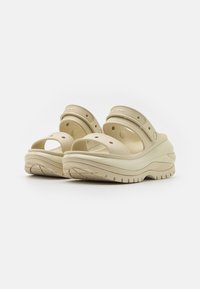 Beige platform sandals with open toe design, multiple ventilation holes, and an adjustable strap. Made of synthetic material with textured sole.
