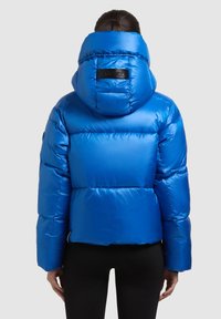 Oblečena modra puhasta jakna z ruto, s prešito strukturo, gladko teksturo in črno logotipno nalepko na hrbtu.