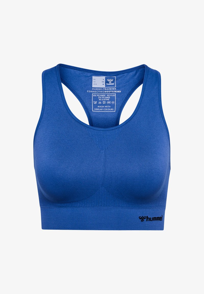 Sujeción deportiva azul con una textura suave, tirantes anchos y un diseño de espalda nadadora. Presenta un logo en la esquina inferior izquierda y una etiqueta de cuidado en el interior.