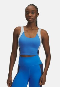 Modrý športový crop top so sivými akcentmi, vyrobený z elastického materiálu, s okrúhlym výstrihom a širokými ramienkami. Kombinovaný s prislúchajúcimi legínami s vysokým pásom.