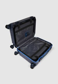 Blauer Hartschalenkoffer mit vier Rollen und einem ausziehbaren Griff, ausgestattet mit einem geräumigen Innenraum, Spanngurten zur Aufbewahrung und einem grauen Mesh-Futter.