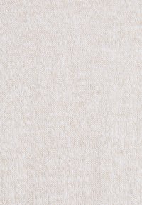 Tissu tricoté de couleur beige clair avec une surface douce et texturée. Présente de petites variations inégales d'épaisseur de fil.