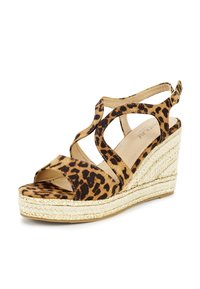 Leopard print wedge sandals with crisscross straps, a jute-wrapped platform, and a subtle gold accent on the edging.