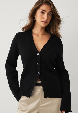Zwarte cardigan met een V-hals, voorzien van vijf knopen aan de voorkant, gemaakt van textuurmateriaal. Lange mouwen met een ontspannen pasvorm.