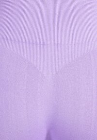 Lichtpaars ribstof met een gestructureerd patroon, met een V-vormig ontwerp in het midden. Glad, rekbaar materiaal, geschikt voor sportkleding.