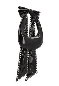 Černá kabelka z lakované kůže s velkou mašlí, dlouhými splývavými popruhy a stříbrnými nýty podél okrajů. Zaoblený tvar a lesklý povrch.