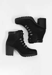 Zwarte enkellaarsjes van gestructureerd leer, met een blokhak, vetersluiting met zilveren oogjes en een robuuste zool.