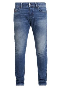 Obcisłe niebieskie dżinsy z przetarciami, zapinane na guziki, z pięciokieszeniowym designem. Kontrastowe przeszycia i mała naszywka z logo marki z tyłu.