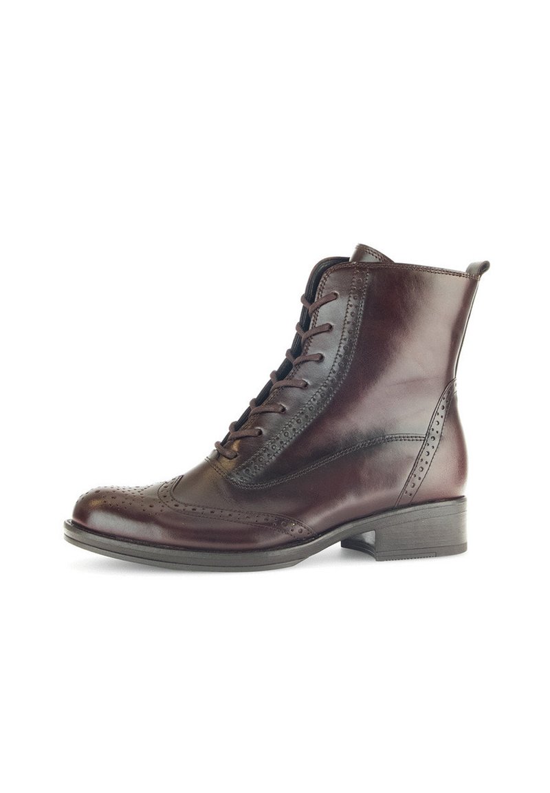 Bruine leren enkelboot met vetersluiting, brogue-details, ronde neus en een lage blokhak. Gladde textuur met een gepolijste afwerking.
