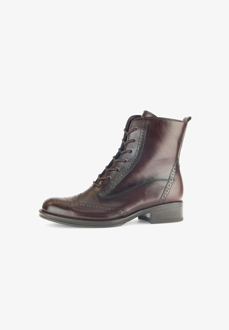 Bruine leren enkelboot met vetersluiting, brogue-details, ronde neus en een lage blokhak. Gladde textuur met een gepolijste afwerking.