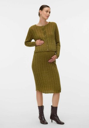 Olivengrøn, ribbet strikket graviditetssweater og midi-nederdel sætl med knapdetaljer, båret med brune ankelstøvler. Tekstureret, tætsiddende design.