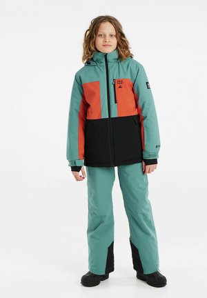 Schneeanzug bestehend aus Jacke und Hose in Türkis, Orange und Schwarz mit Farbblokkmuster. Das Material wirkt wasserabweisend und verfügt über einen Reißverschluss an der Vorderseite sowie eine Kapuze.