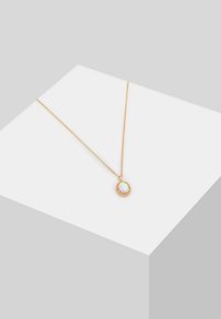 Goldkette mit einer zarten Kette und einem runden Opal-Anhänger, umgeben von einem strukturierten goldenen Rahmen, der das Licht mit irisierenden Farbtönen reflektiert.
