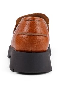 Brauner Lederschuh mit strukturiertem Obermaterial und kontrastierender schwarzer Gummisohle, ausgestattet mit einem flachen Absatz und einem abgerundeten Rückendesign.