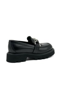 Mocassini in pelle nera con suola di gomma spessa, dotati di una fibbia decorativa in argento e un design con punta arrotondata. Texture liscia con dettagli cuciti.