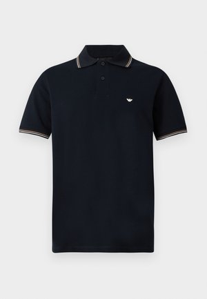 Navy blue short-sleeve polo shirt with two-button placket, white and beige striped collar and sleeve edges, and small white logo on chest.