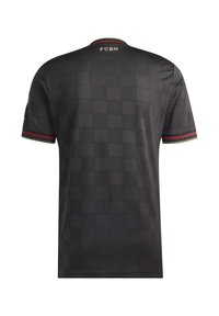 Black checkered sports jersey with red and green trim on sleeves and collar, "FCBM" text near the neckline on the back.