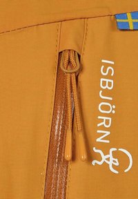 Orange tyg med en slät textur har en dragkedja med två dragpullar. Vit text "ISBJÖRN" och en blå och gul flagga är synliga.