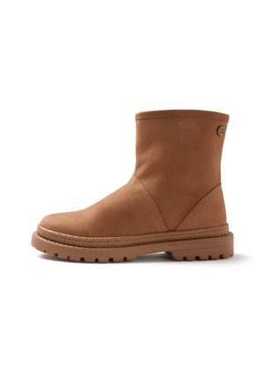 Bota de ante marrón hasta media pantorrilla con puntera redonda, suela gruesa con dibujo y pequeña etiqueta redonda de la marca cerca del borde superior sobre fondo blanco.