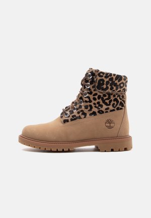 Bottine à lacets couleur fauve avec col rembourré imprimé léopard et semelle épaisse en caoutchouc, logo Timberland sur le côté.