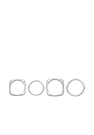 Cuatro anillos minimalistas de plata con formas alternadas de cuadrados redondeados y círculos, dispuestos en línea horizontal sobre un fondo blanco.