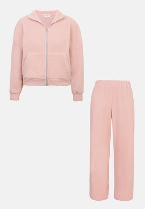 Chaqueta de forro polar con cremallera frontal, mangas largas y bolsillos laterales, combinada con pantalones de forro polar a juego. Ambos en un suave color rosa claro.