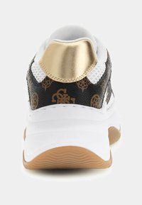 Schwarz-weißer Sneaker mit goldenem Akzent an der Ferse, strukturiertem Obermaterial mit Logomustern und einer braunen Gummisohle.