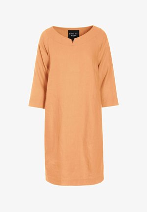 Robe longueur genou de couleur pêche avec manches trois-quarts, col arrondi et petite découpe frontale.