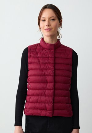 Gilet imbottito bordeaux con alto colletto, design trapuntato e zip frontale. Realizzato in materiale leggero, adatto per essere indossato a strati.