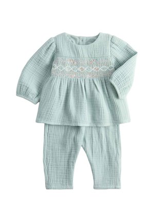 Blødt lyseblåt baby sæt med langærmet top og bukser i tekstureret stof med broderede pastelfarvede diamantmønstre over brystet.
