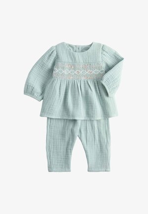 Blødt lyseblåt baby sæt med langærmet top og bukser i tekstureret stof med broderede pastelfarvede diamantmønstre over brystet.