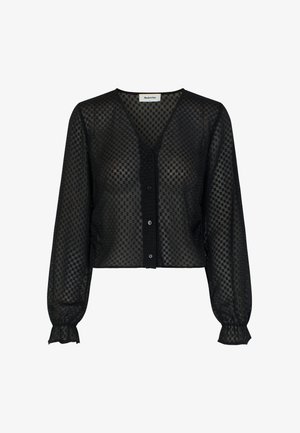 Čierna priehľadná blúzka s výstrihom do V, dlhými nafúknutými rukávmi a gombíkovým zapínaním. Má kockovaný vzor a zhromaždené detaily na manžetách.